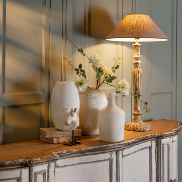 Französische Tischlampe auf Vintage Sideboard mit Keramikvasen im ruhigen Landhausstil