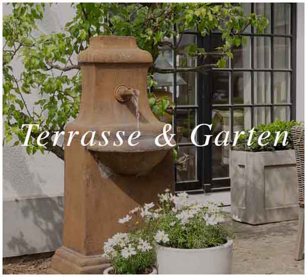 Terrasse im mediterranen Stil mit Steinfontaine und üppiger Begrünung — Charme de Provence Berlin