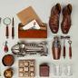 Preview: Flamant Manhattan Lederkollektion Flatlay mit Cocktailshaker, Lupe, Brieftasche und Rennwagenstatue