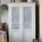 Preview: Altfranzösischer Wäscheschrank im Schlafzimmer — Frontansicht mit perforiertem Kreuzgitter, antique crème Finish, Provence-Landhausstil
