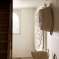 Preview: Tine K Rundkorb aus Palmblatt an weißer Wand hängend — flache Form, 2 Henkel, naturfarbenes Geflecht, mediterranes Interieur
