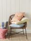 Preview: Kissen aus Streifenstoffen von Jane Churchill auf einem Rattansessel