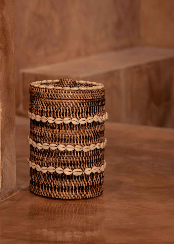 Preview: Muschelkorb aus Rattan mit Kaurimuscheln auf einer Holzablage