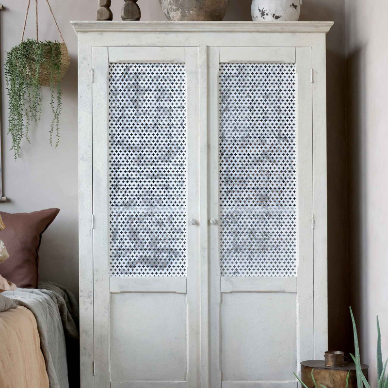 Preview: Altfranzösischer Wäscheschrank im Schlafzimmer — Frontansicht mit perforiertem Kreuzgitter, antique crème Finish, Provence-Landhausstil