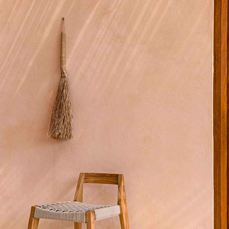 Preview: Grumpy Broom an terrakottafarbener Wand hängend, mit Holzstuhl darunter – Ambiente-Aufnahme