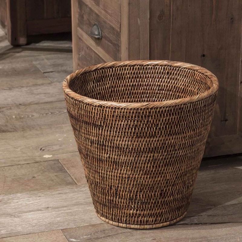 Papierkorb Togo aus Rattan auf einem Holzboden vor einer Kommode