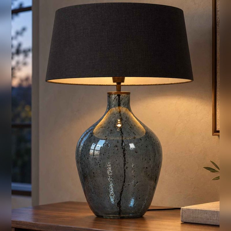 Preview: Glasleuchte Cleria am Abend auf einem Sideboard aus Holz