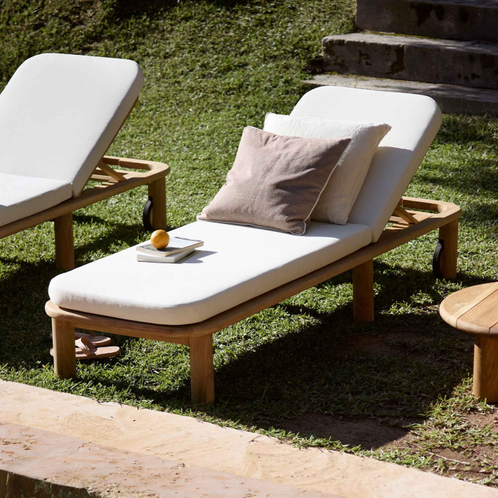 Tine K Teak Sonnenliege im Garten — cremefarbenes Quick-dry Kissen, verstellbare Rückenlehne, Kissen und Buch als Deko, sonniger Rasen