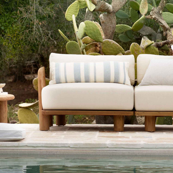Tine K Teak Seitenmodul kombiniert mit Mittelelement am Pool — cremefarbene Kissen mit Streifenkissen, recyceltes Teak, mediterrane Gartenkulisse