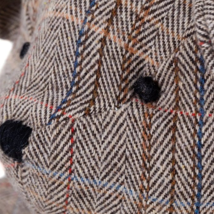 Fischgratstoff und gestickte Augen des Teddybären Marco im Detail